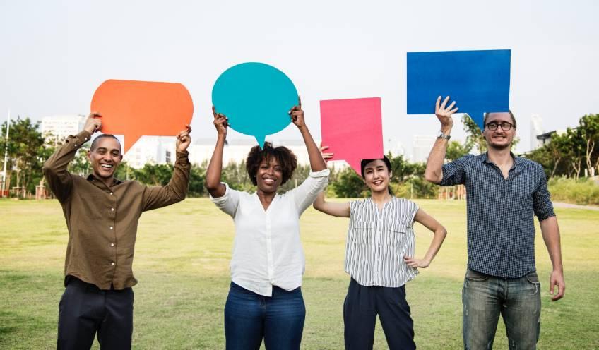 photo of people holding up chat bubbles representing multiple forms of fommunication